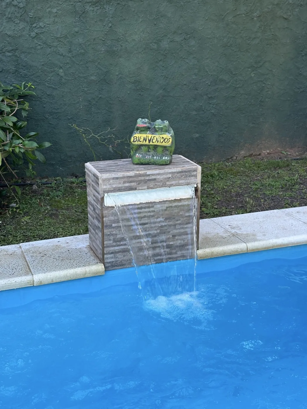 Cascada y cartel de bienvenida de la pileta de Cabaña Cactus I