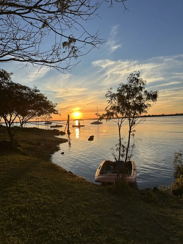 Atardecer sobre el río Paraná con un bote junto a la costa